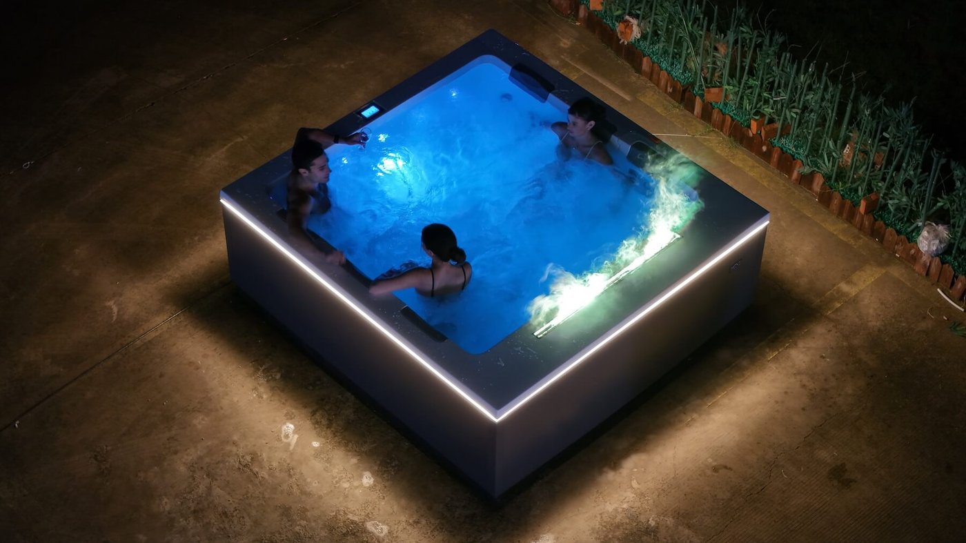 Casa Blui above ground hot tub in a courtyard with flowering plants.