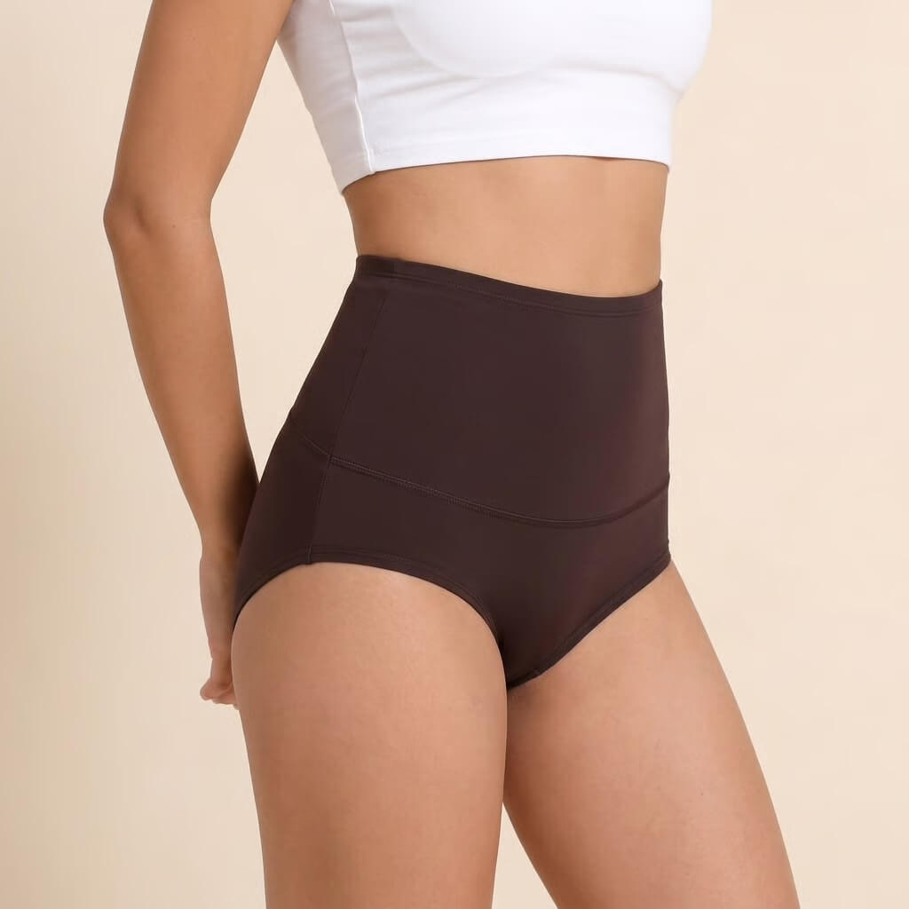 A side view of a person wearing high-waisted, dark brown underwear and a white crop top.