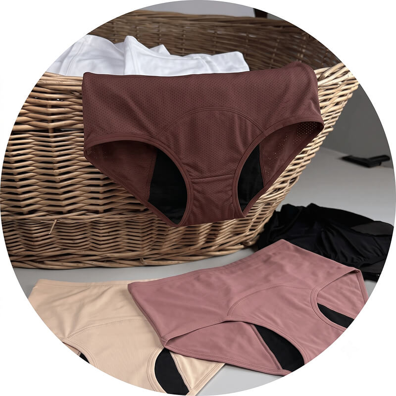 Several pairs of women's underwear in various colors are arranged in and around a wicker basket.