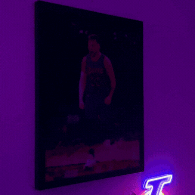 A dimly lit room with a basketball player poster and neon lights.
