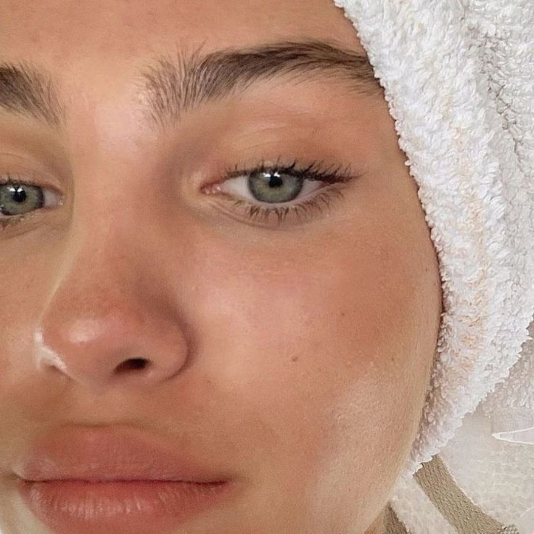 Close-up of a person's face with a towel wrapped around their head.