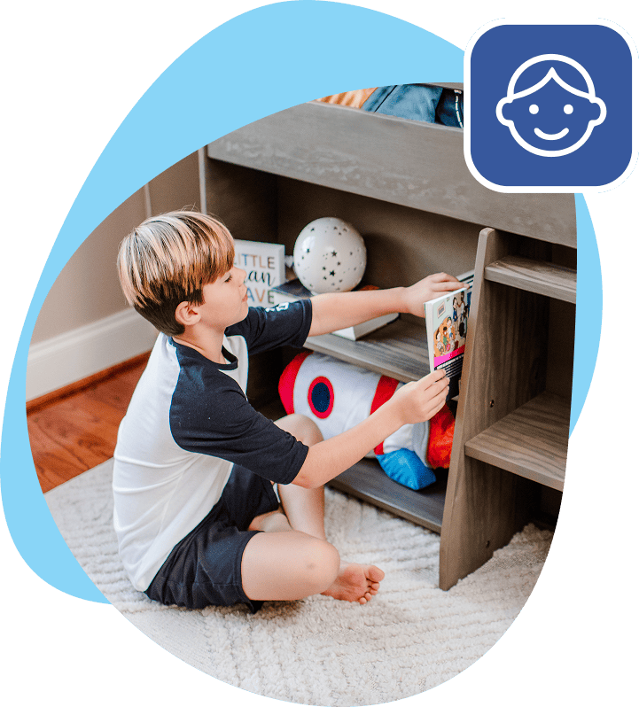 little boy organizing books in storage under bunk bed