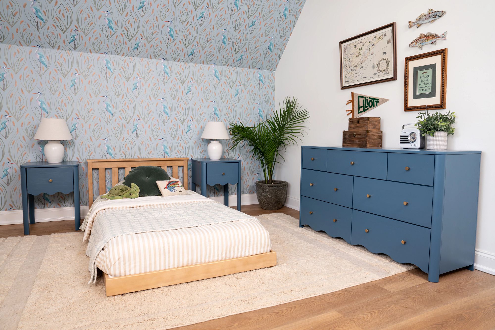 A wooden floor bed in a blue and white bedroom with stylish wave-trim, blue storage dresser and nightstands.