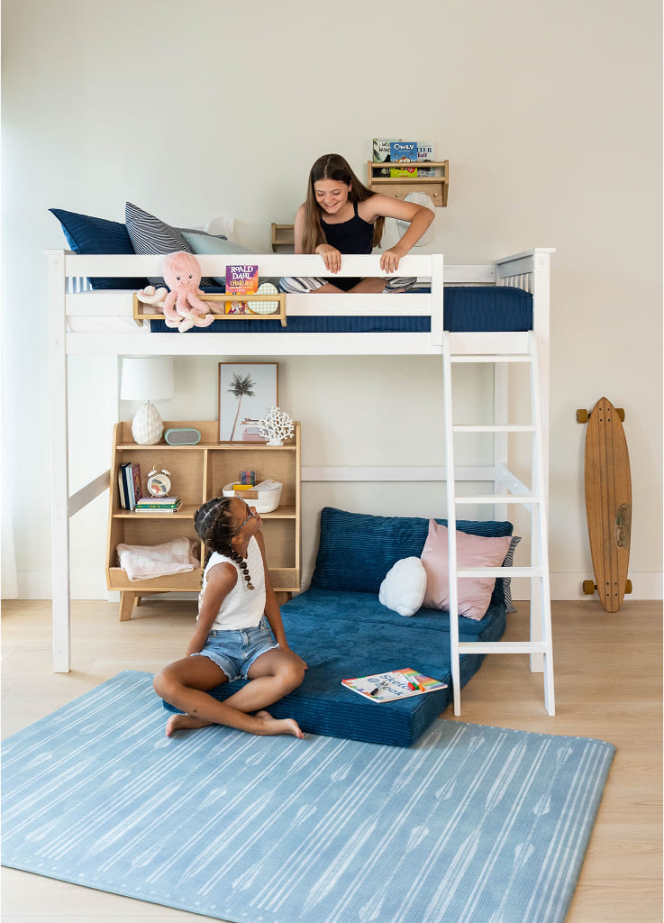 Children enjoying a cozy bedroom with modern loft bed and reading nook.