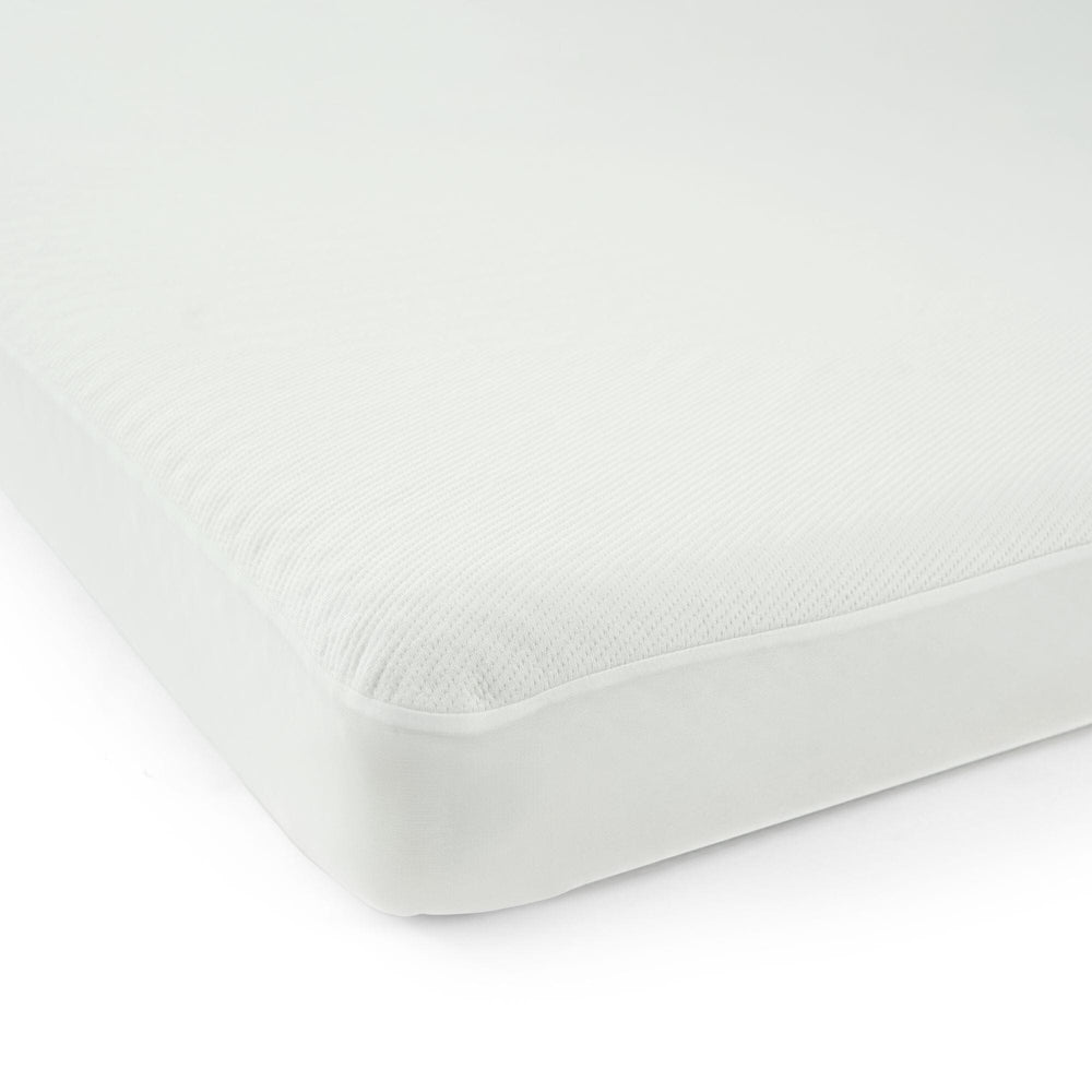 Close-up of a white mattress corner with a textured surface.