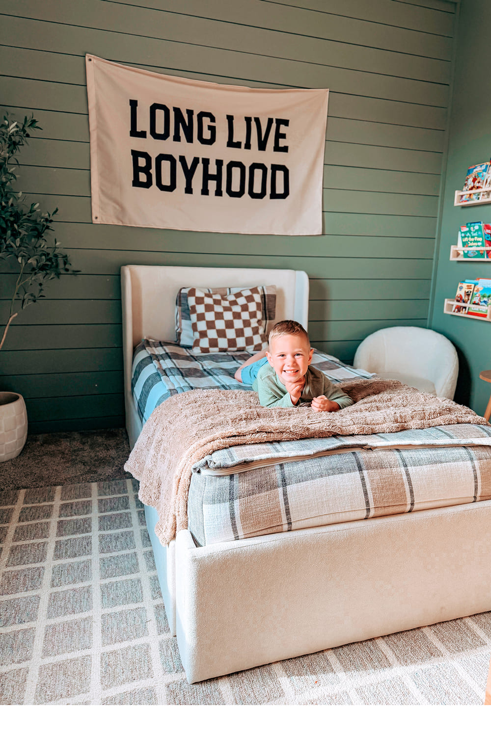Cozy child's bedroom with a playful banner, decorative bedding, and bookshelves filled with children's books.