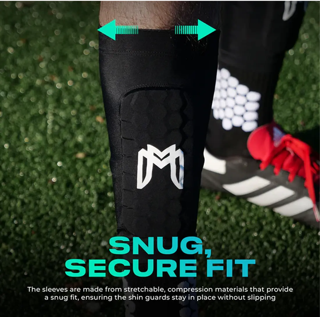 Close-up of a leg wearing a black shin guard on a grassy field.