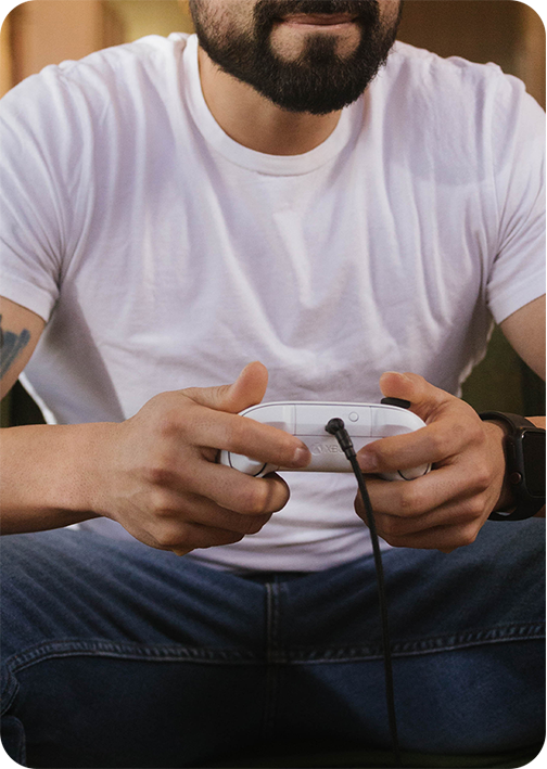 Person in white shirt holding a video game controller.