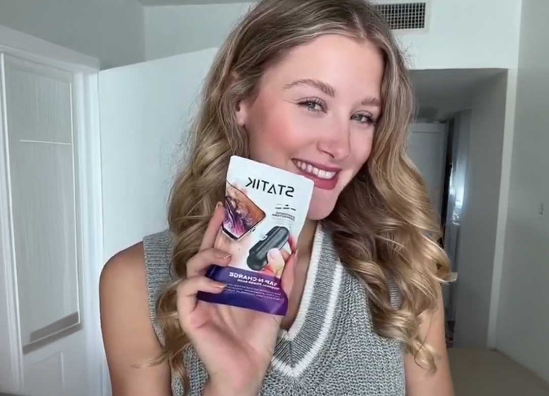 Person smiling and holding a product package labeled 'STATIK'.