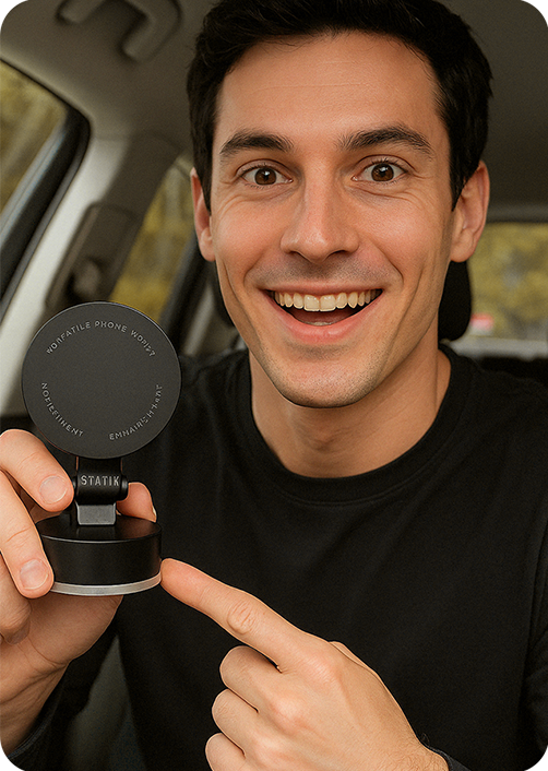 Person in a car holding a phone mount, smiling and pointing at it.