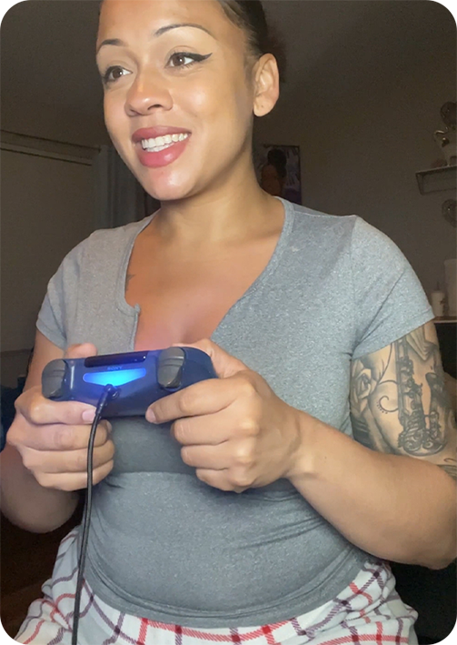 Person smiling while holding a game controller with a glowing light.