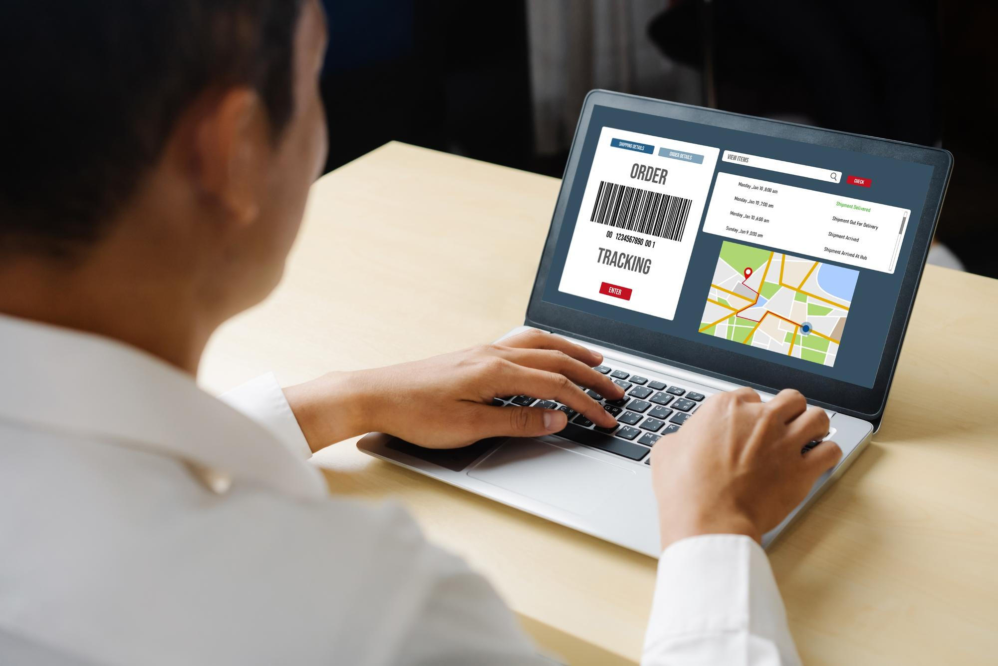 Person using a laptop with order tracking and map on screen.