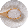 A wooden spoon filled with white granulated sugar, resting on a pile of more sugar.