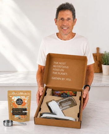 Man holding open The Sprouting Company starter kit box with sprouter and seed bag