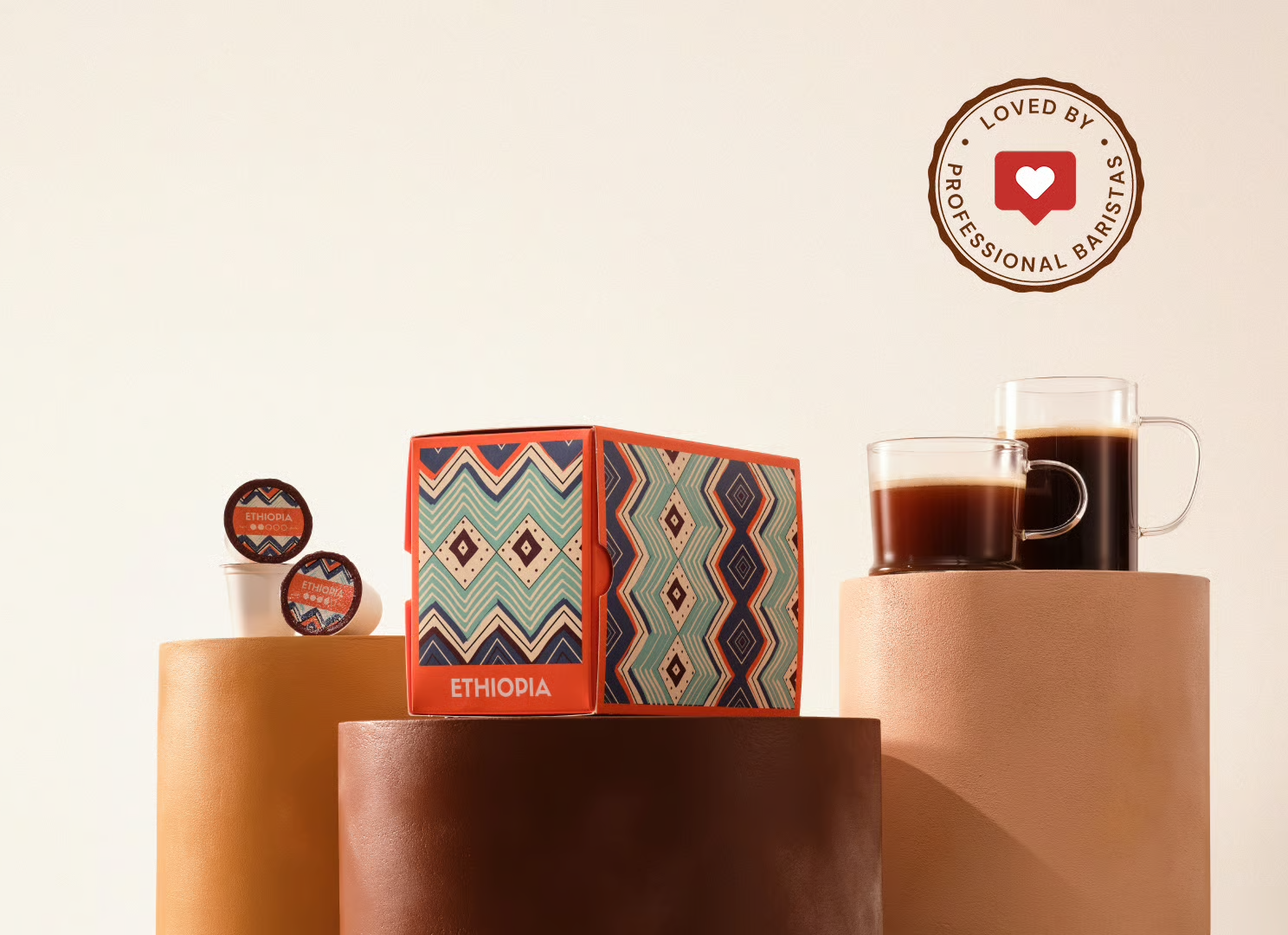 A box of Ethiopia coffee pods displayed on pedestals with two mugs of brewed coffee.