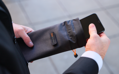 A person placing a smartphone into a GoDark Faraday Bag for Phones