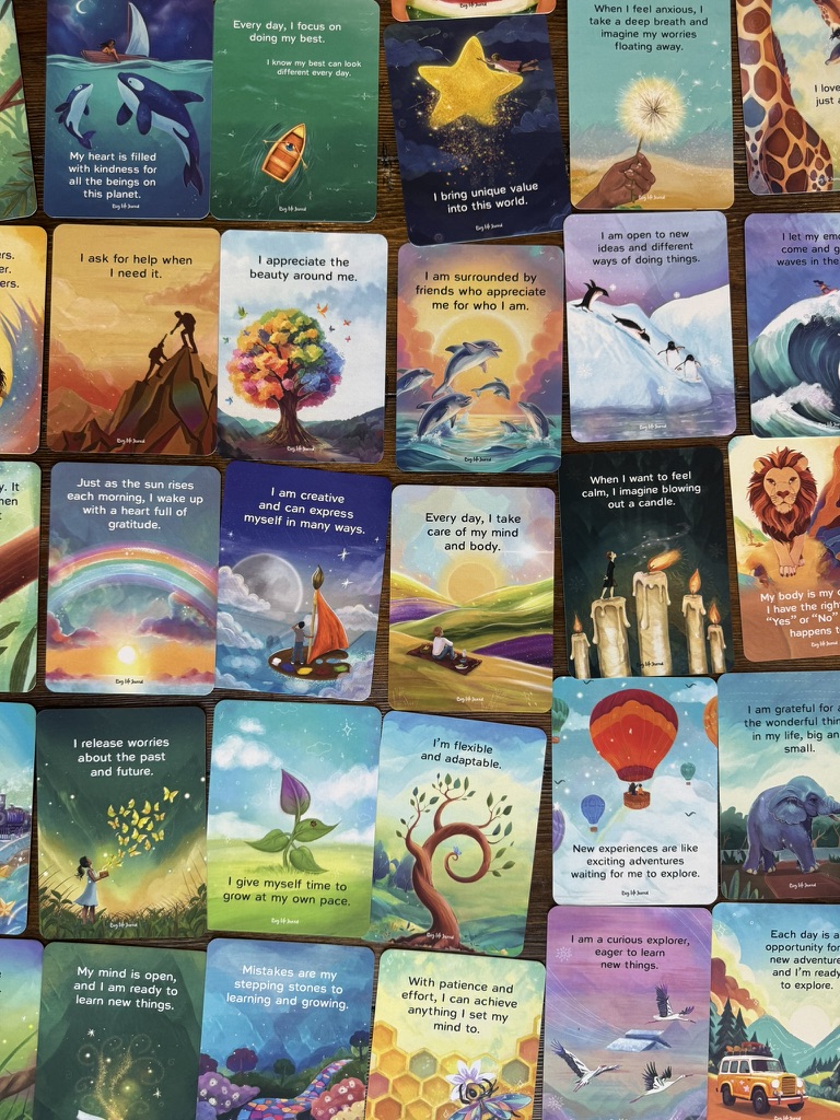 A collection of colorful illustrated cards, each with an inspirational quote, are spread out on a surface.