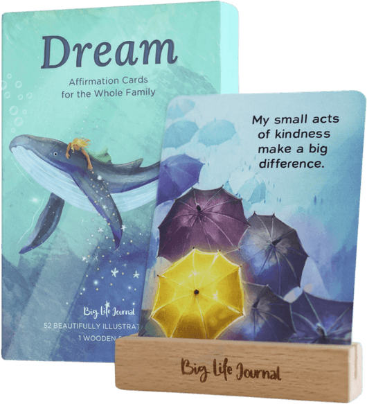 A box of 'Dream Affirmation Cards' with a sample card displayed in a wooden Big Life Journal stand.