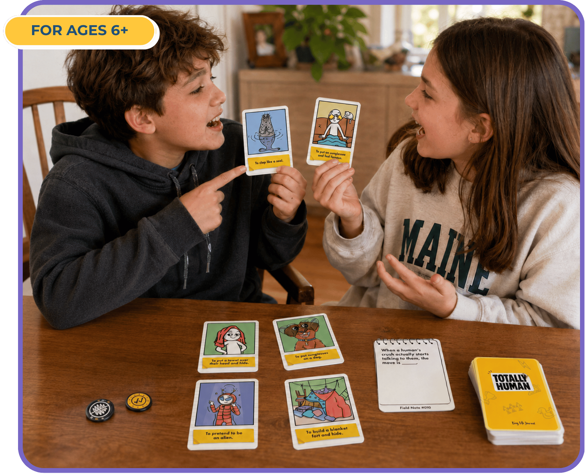 Two children sit at a wooden table playing a card game called 'Totally Human'.