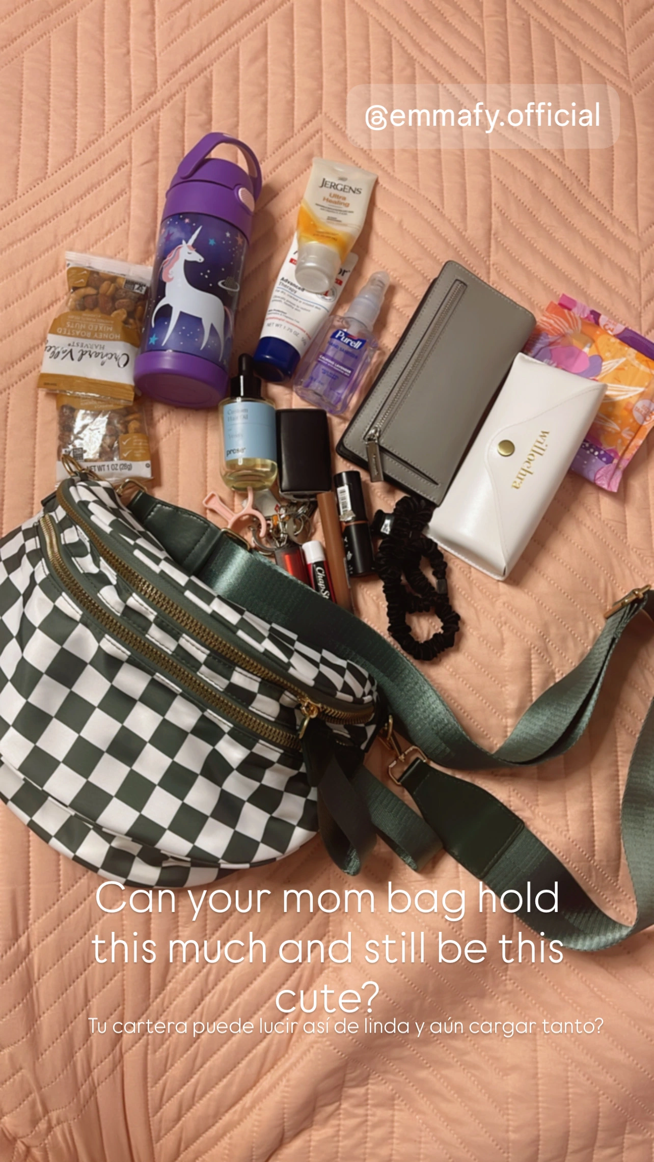 Checkered bag with various items like a water bottle, snacks, and cosmetics on a quilted surface.