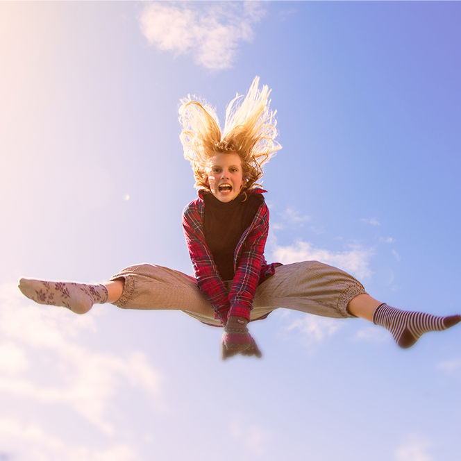 Person jumping in the air with a blue sky background.