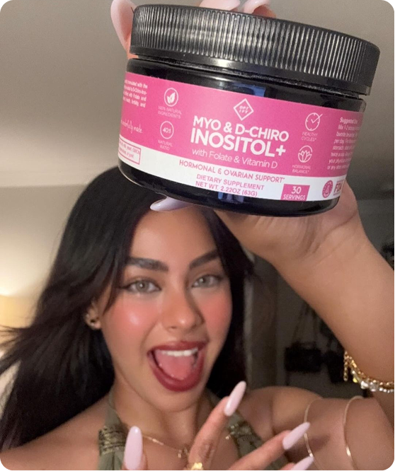 A smiling woman holds up a black jar of Myo & D-Chiro Inositol+ dietary supplement.