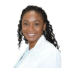 Headshot of a smiling Black woman with long braided hair wearing a white lab coat.