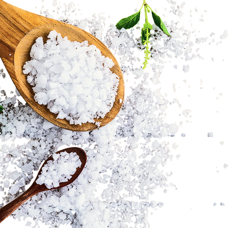 Wooden spoons with coarse salt and a green leaf on a green background.