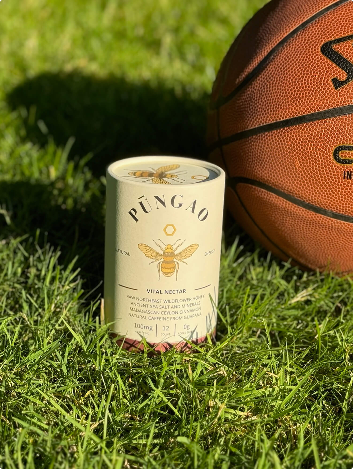 A can of Pungao Vital Nectar on grass beside a basketball.