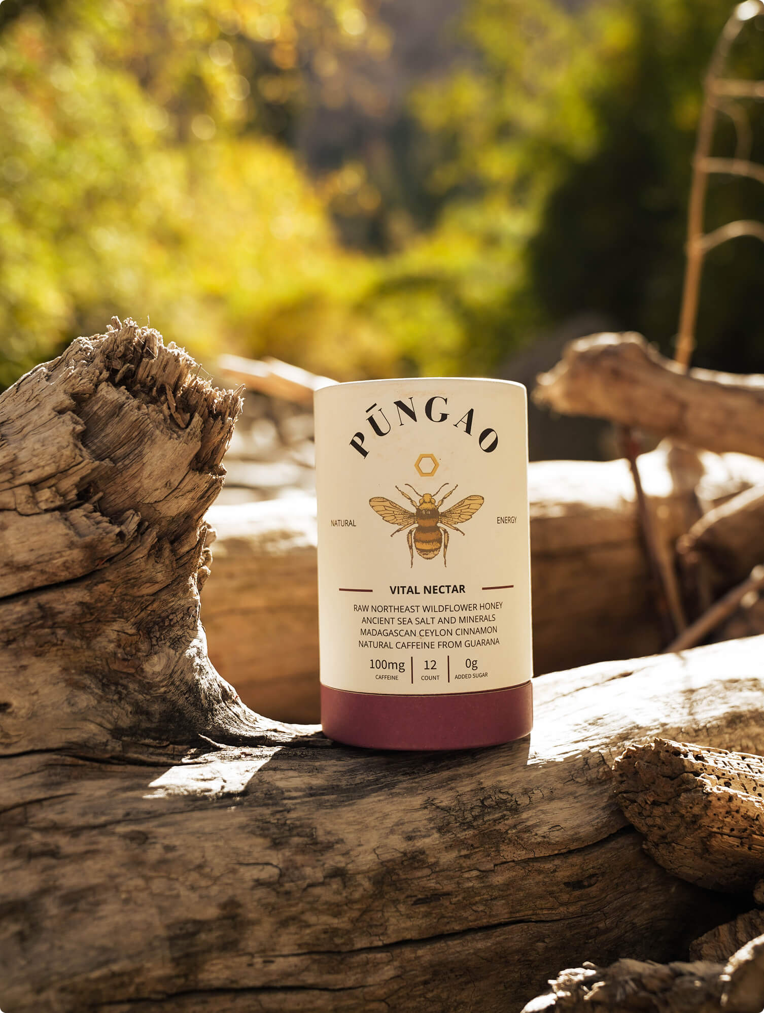 A container of Pungao Vital Nectar on a log in a natural setting.