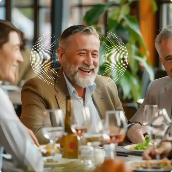 Three men smiling at a dinner table with glasses and dishes.