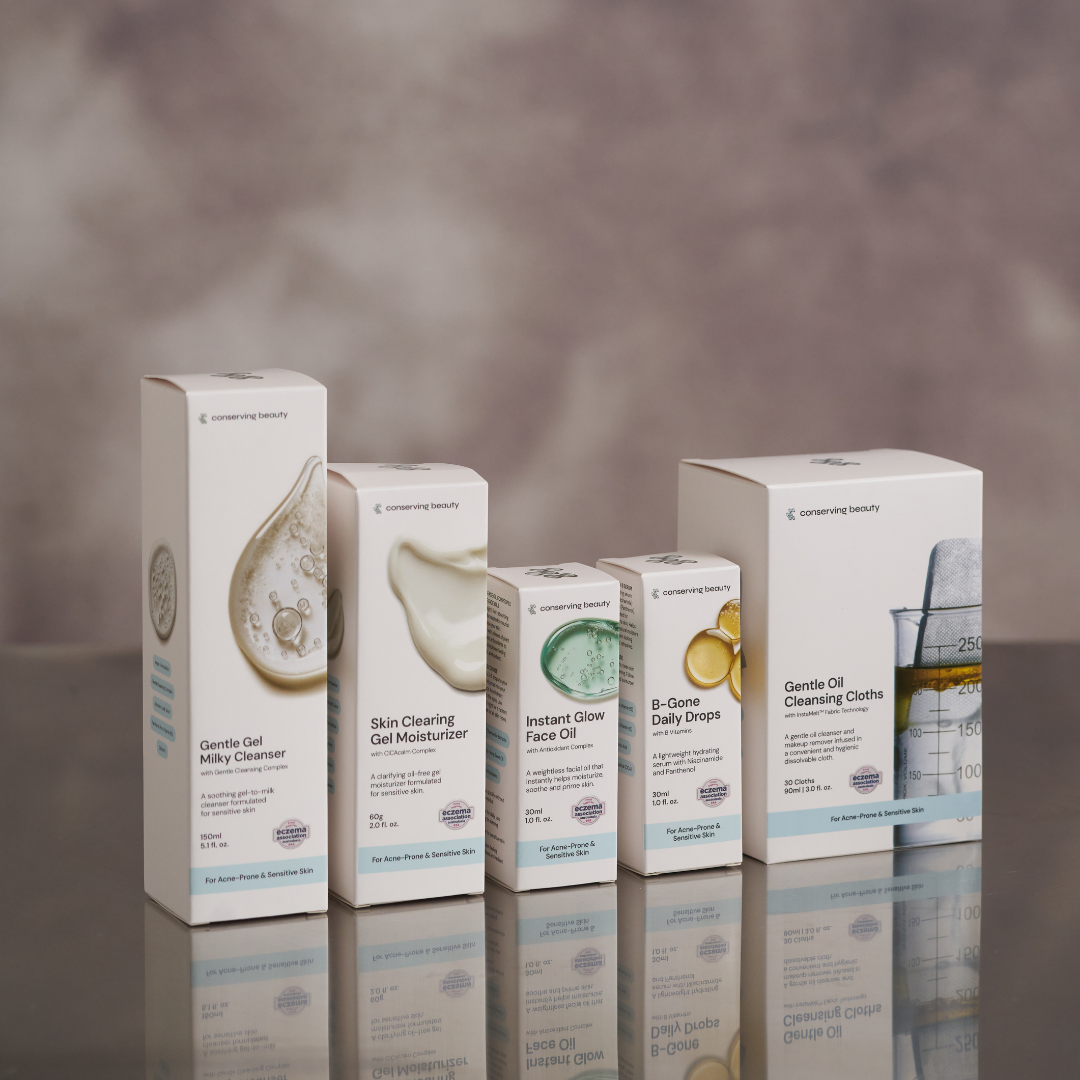 Five skincare product boxes on a reflective surface, each with different labels.