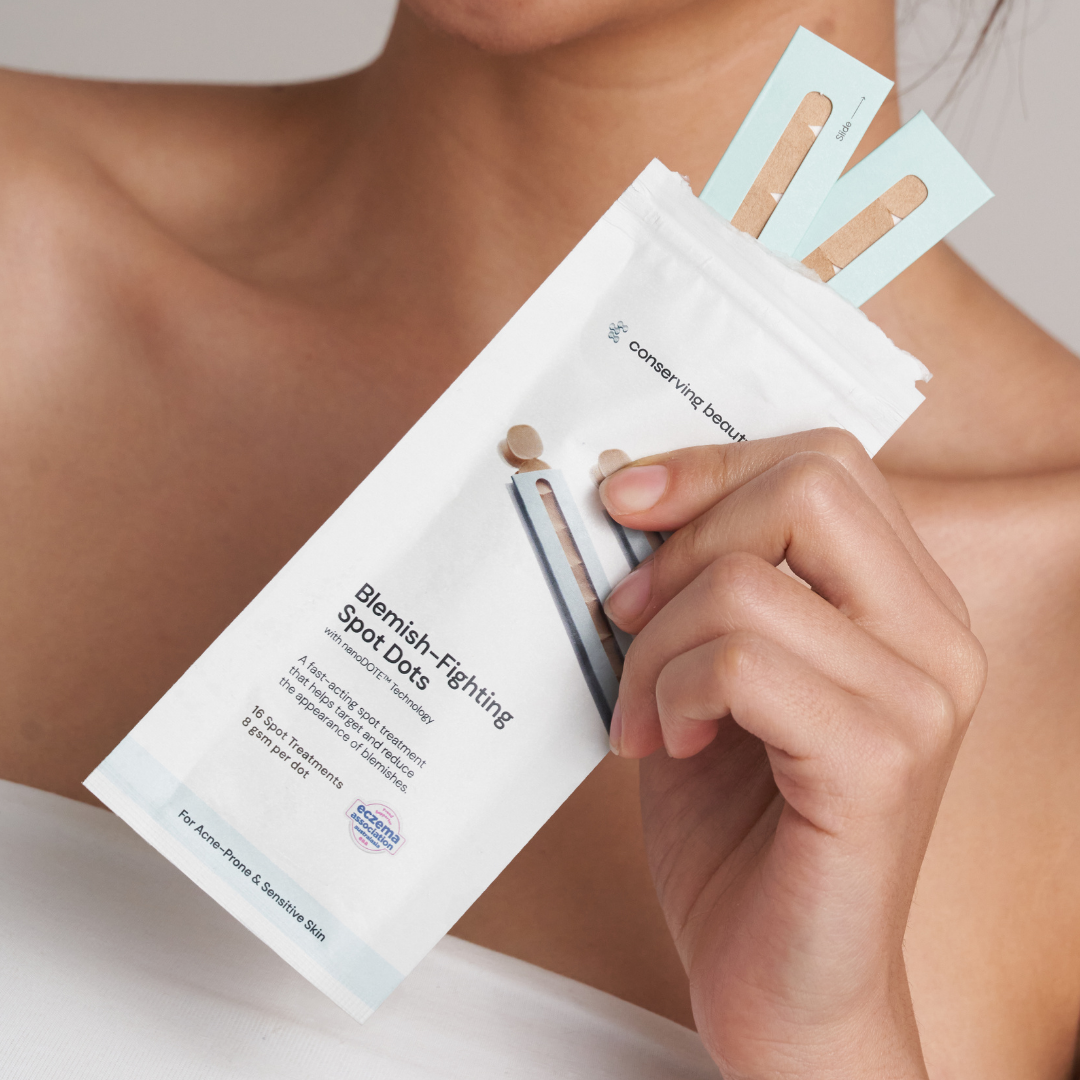 Person holding a packet of blemish-fighting spot dots.