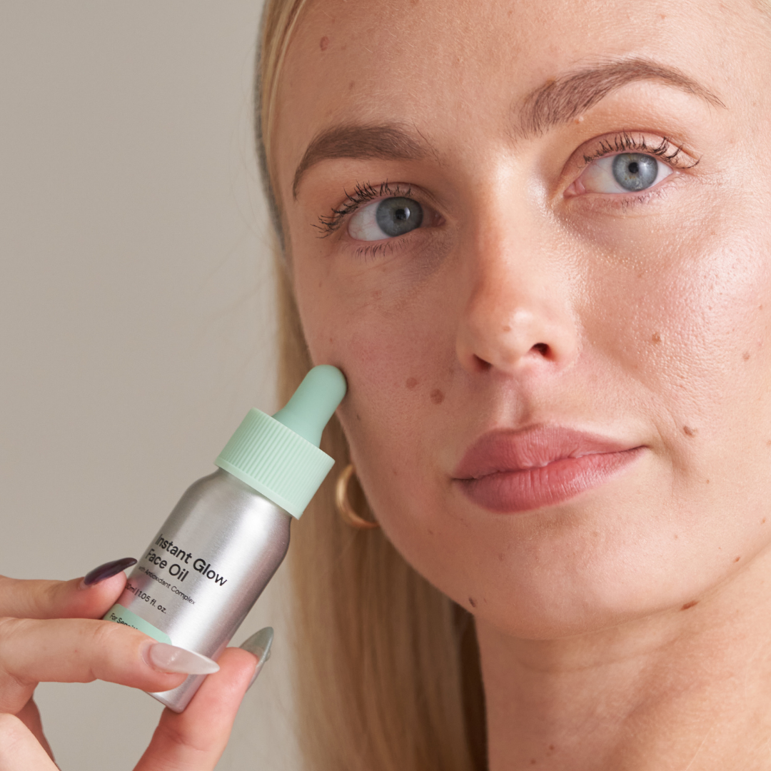 Person applying face oil with a dropper.