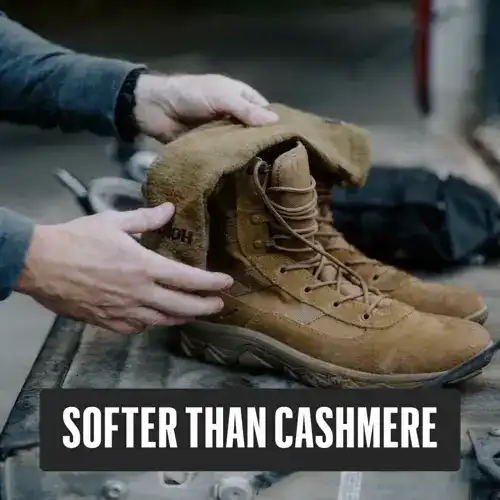 A person's hands display the soft, fleece-like lining of a pair of tan tactical boots.
