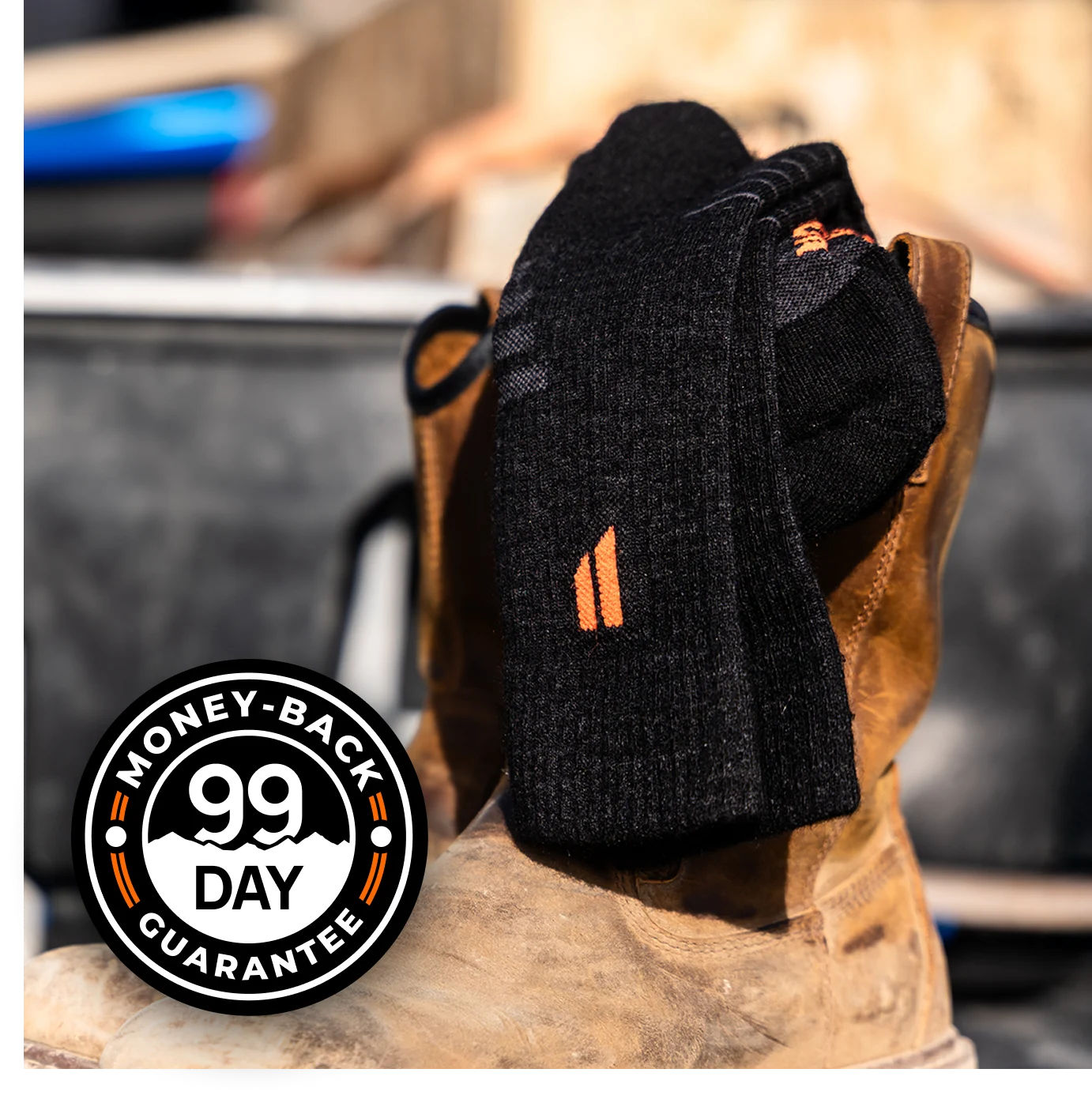 Black socks on a brown boot with '99 Day Money-Back Guarantee' seal.