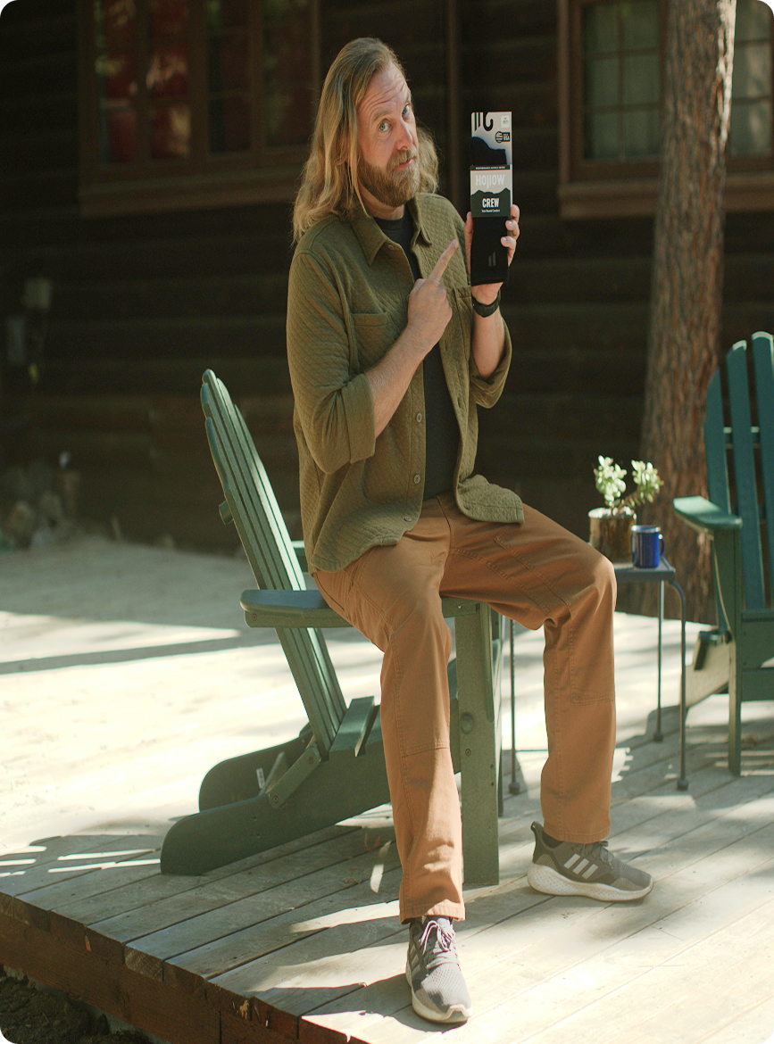 Person sitting on a deck, holding and pointing at a product package.