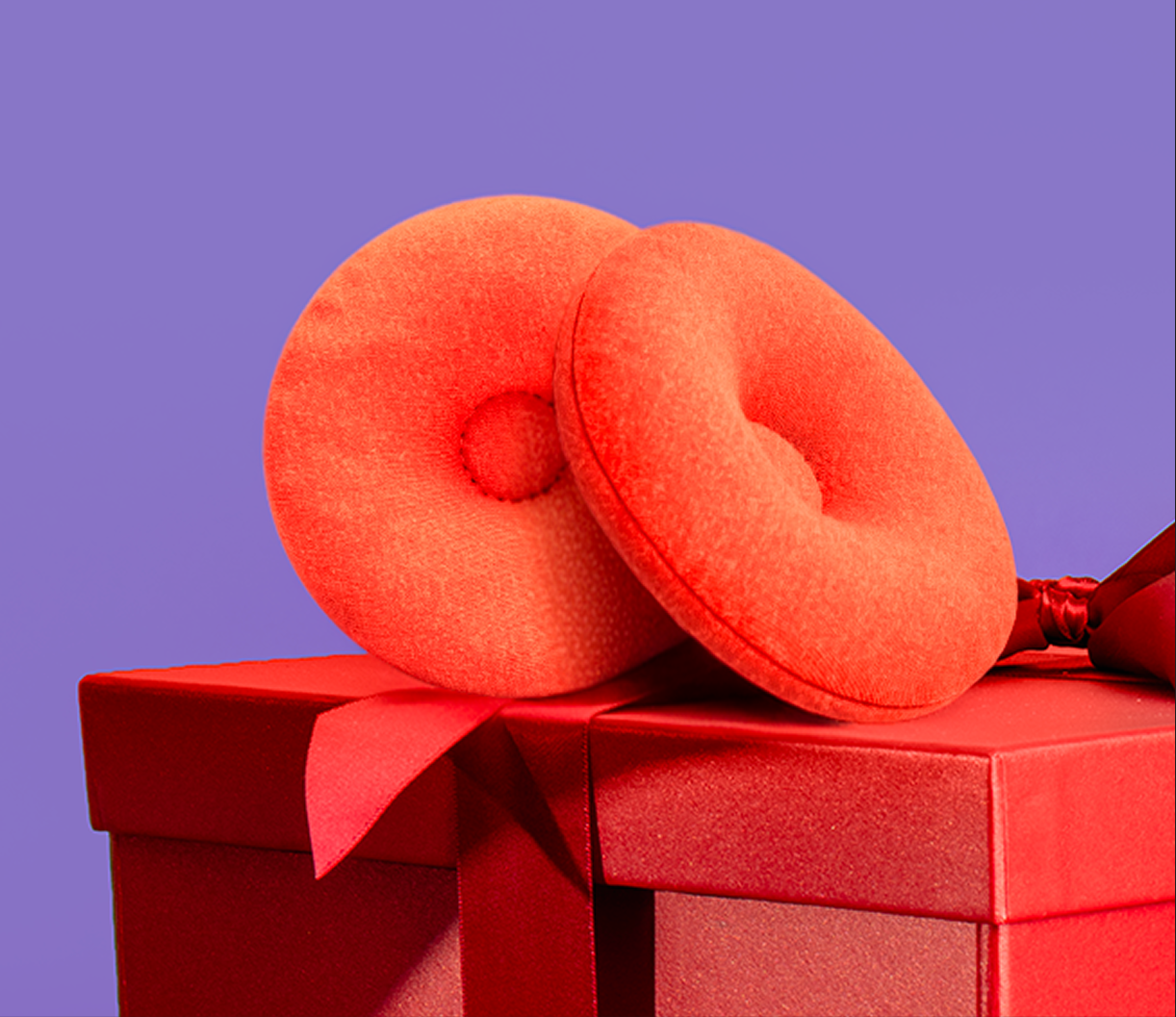 Two red cushioned rings on a red gift box with a purple background.
