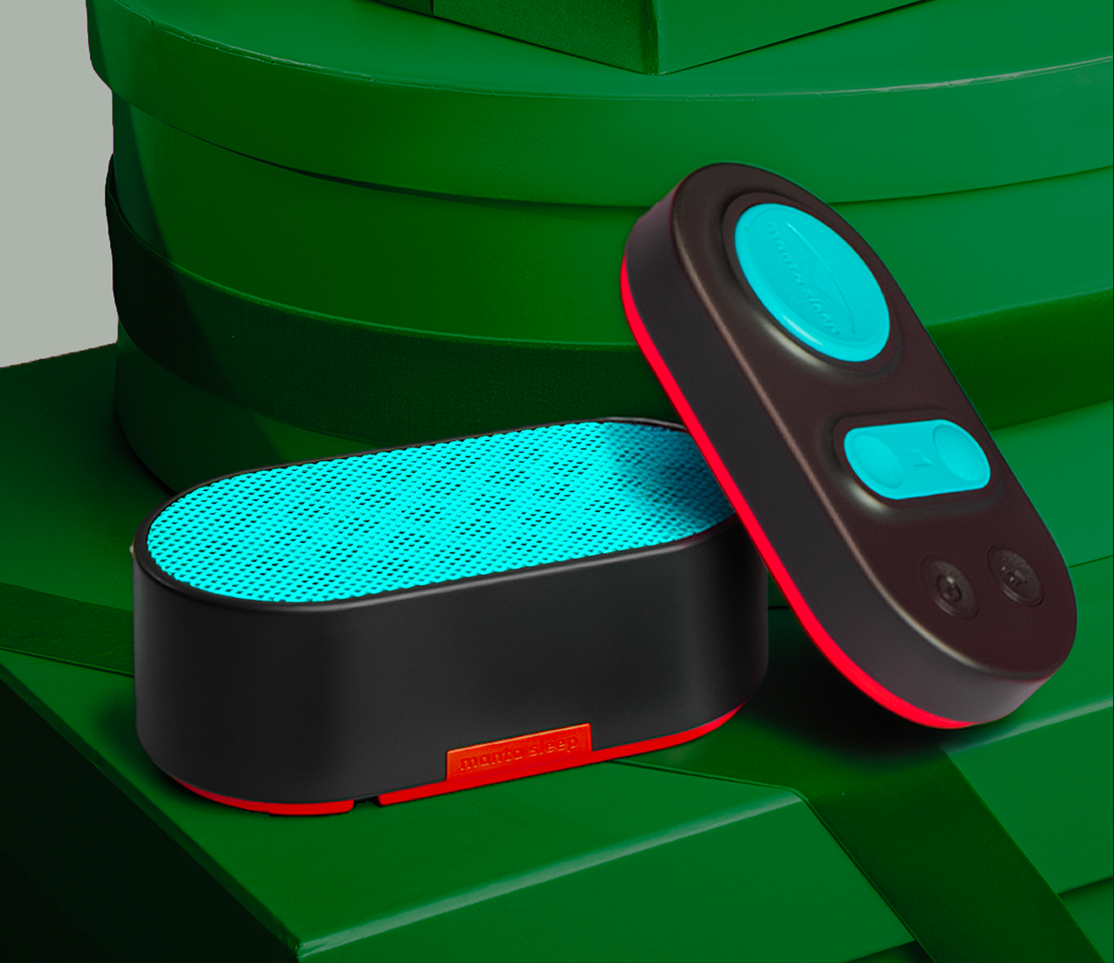 Two electronic devices on a green surface, one is flat and blue, the other has buttons.