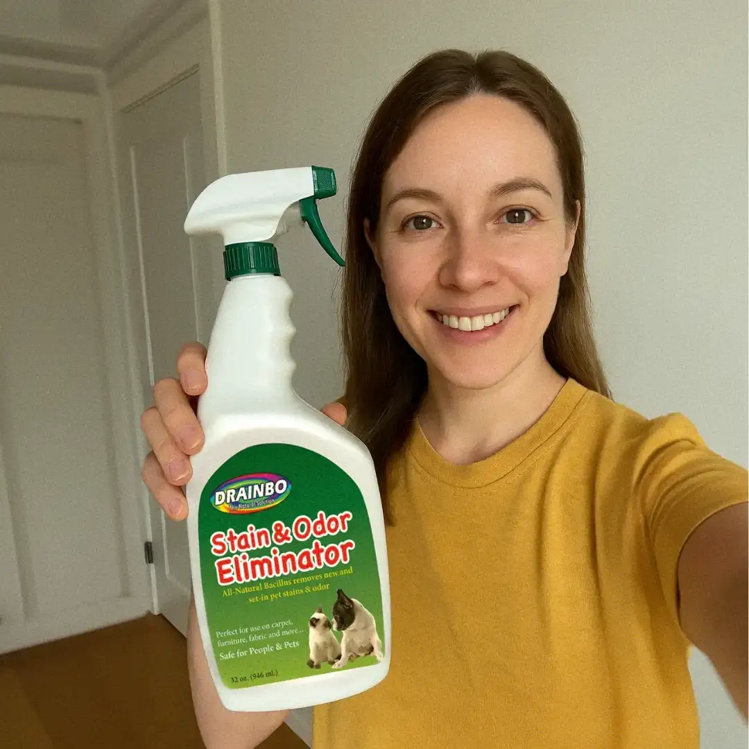 Person holding a bottle of stain and odor eliminator spray.