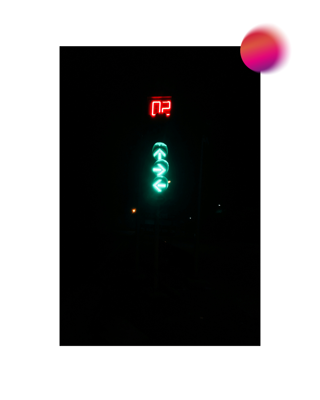 A traffic light at night with three green left-turn arrows and a red digital countdown timer showing 02.