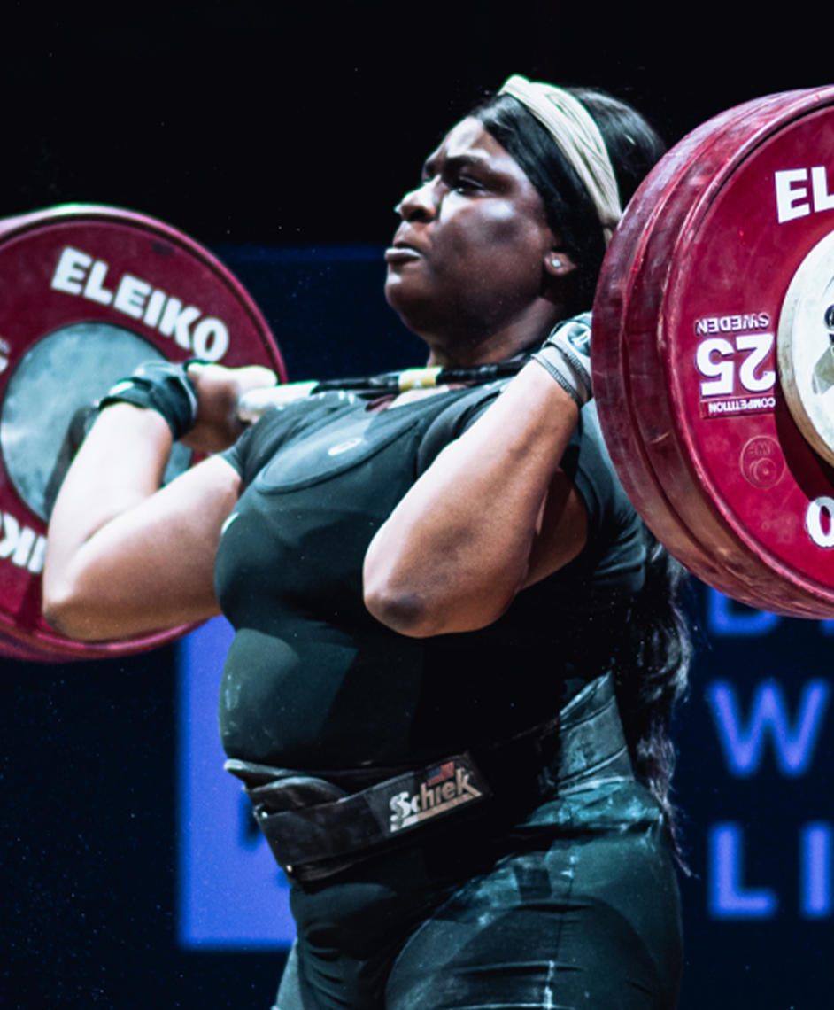 Person lifting heavy barbell weights in a gym.