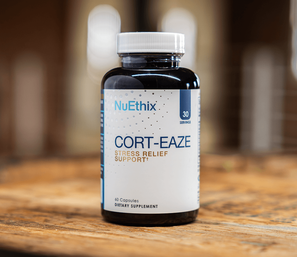 A bottle of NuEthix Cort-Eaze stress relief support dietary supplement sitting on a wooden surface.