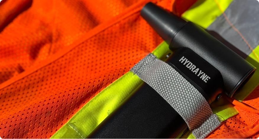 Black tool labeled 'HYDRAJYNE' on an orange safety vest.