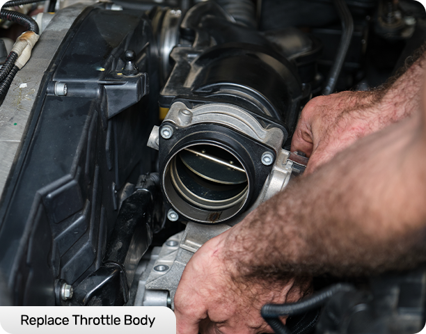 Hands working on a car engine's throttle body.