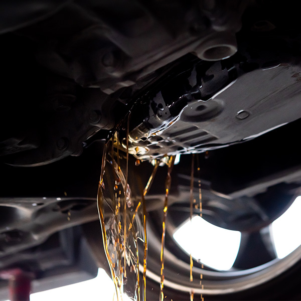 Oil draining from a car's engine undercarriage.