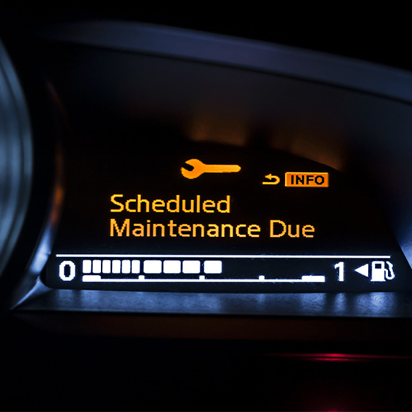 Car dashboard displaying 'Scheduled Maintenance Due' warning.
