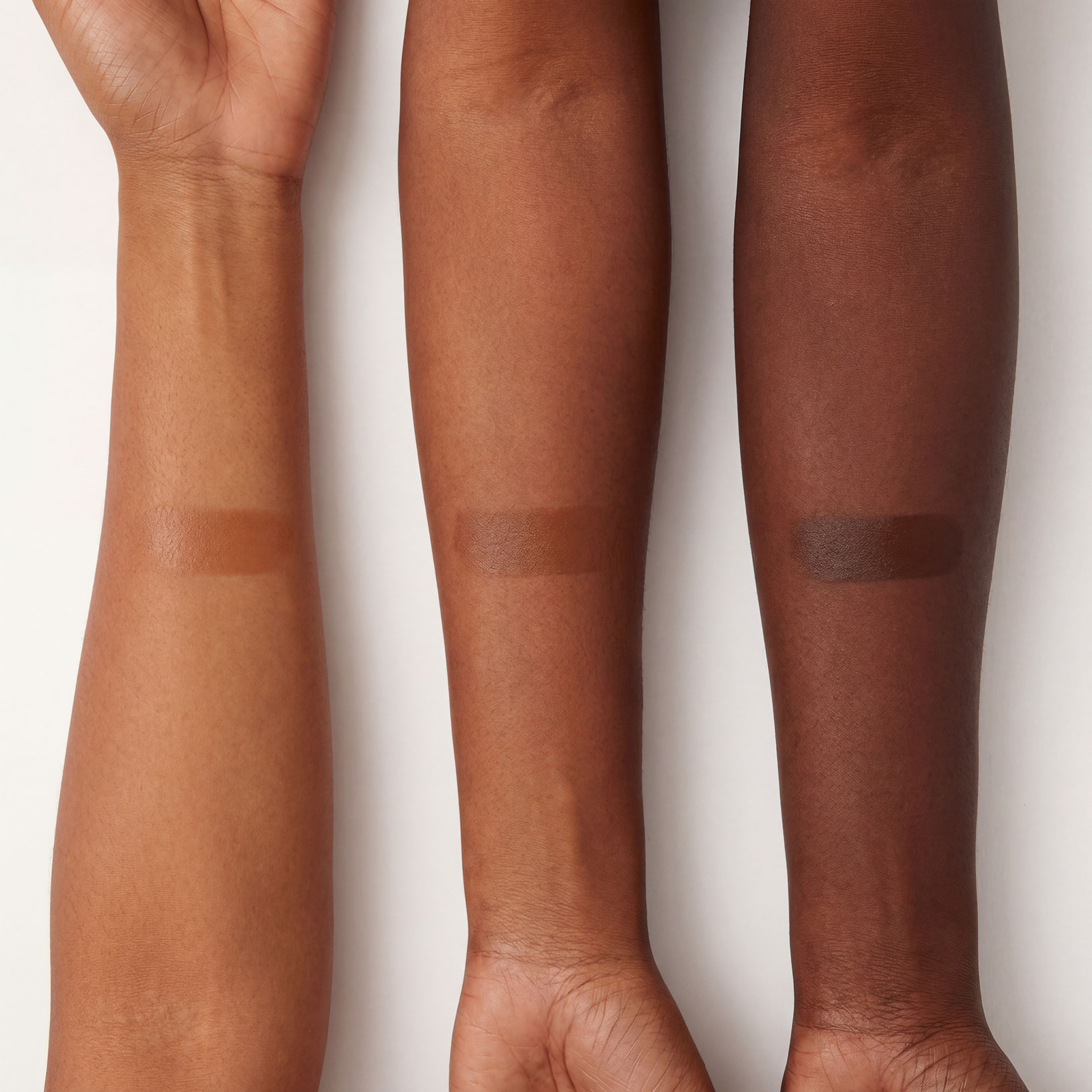 Three arms with varying skin tones, each with a rectangular swatch of makeup on the forearm.