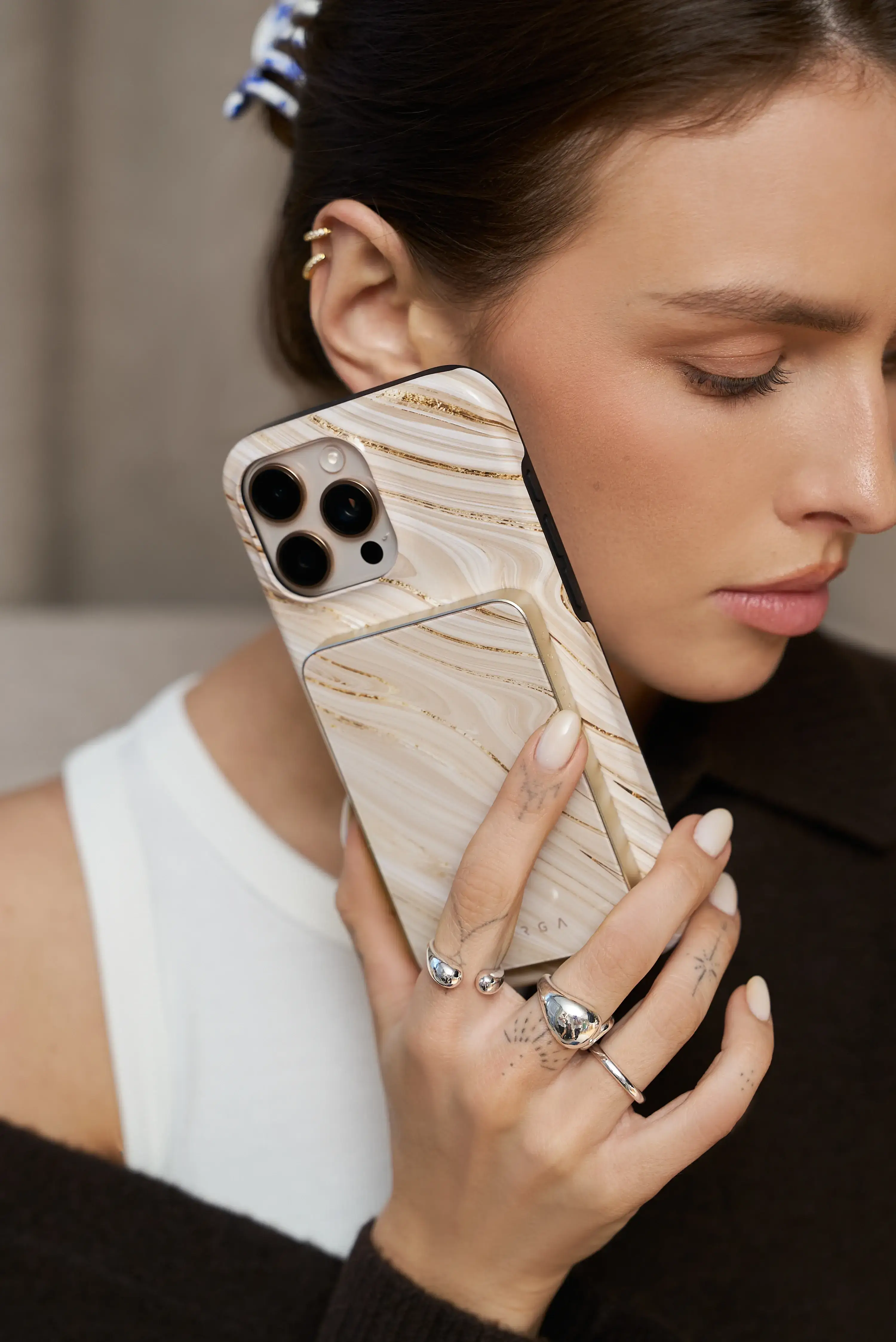 Person holding a phone with a marble-patterned case to their ear.