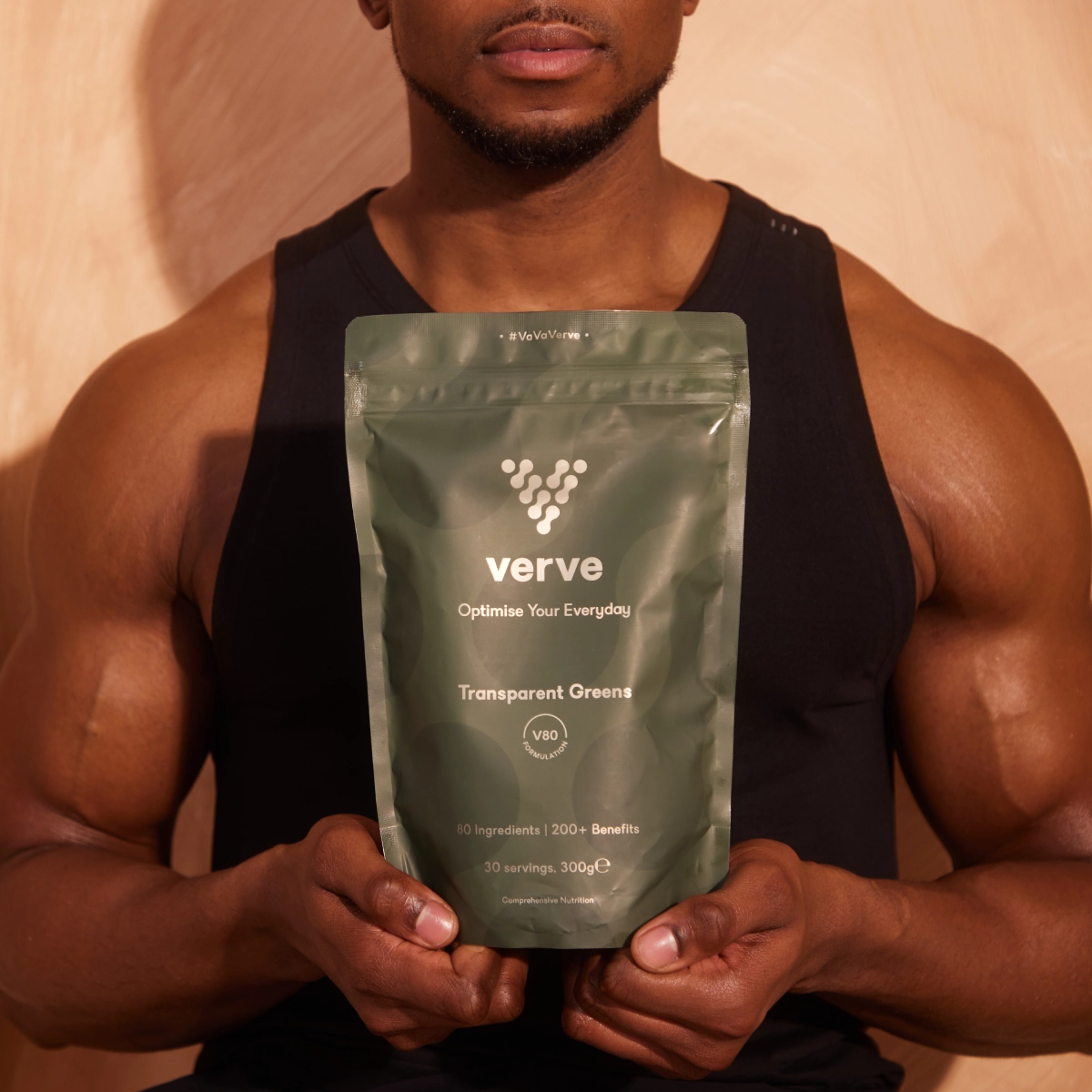 Person holding a green Verve supplement package against a neutral background.